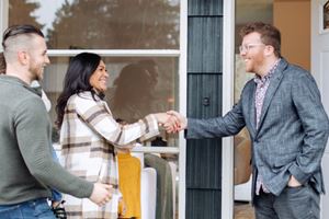 Real Estate Agent meeting and shaking hands with potential homeowners