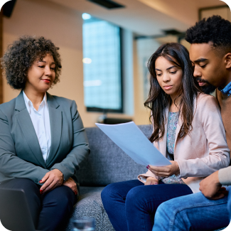 Young couple sitting down to discuss finances with an advisor.