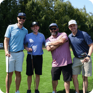 Group of four guys at a golf tournament.