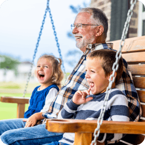 Older gentleman sitting with his grand kids.