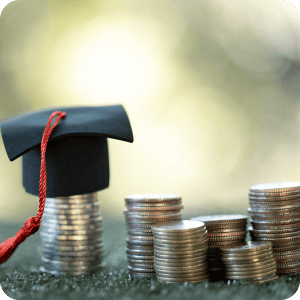 Mini graduation cap on a stack of coins.