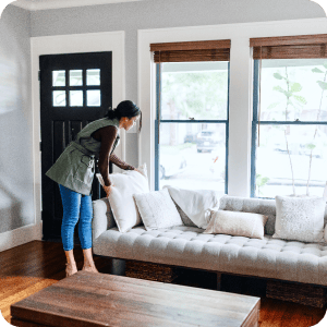 Woman fixing the pillows on her couch.