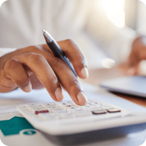 Hand using a calculator on a desk.