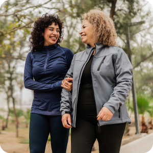 Mother and daughter embracing each other while out on a walk.