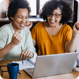 Two women looking at a laptop together.