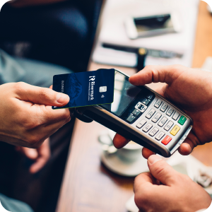 Man paying for coffee with his Rivermark Cash Back credit card using tap to pay.