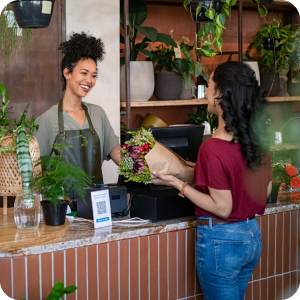 Woman buying a bouquet of flowers at a local plant shop.