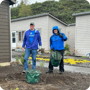 Two Rivermark employees volunteering outside.