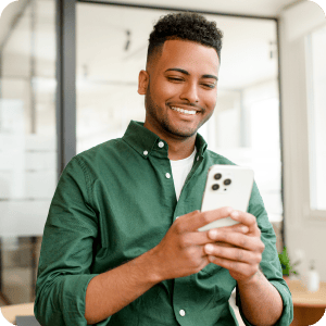 Young man looking at his phone and smiling.