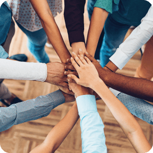 A diverse group of hands piled together in a circle.