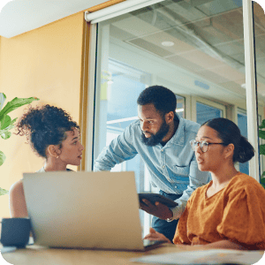 Three people looking at a computer together.