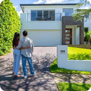 Young couple standing outside their newly purchased home admiring it.