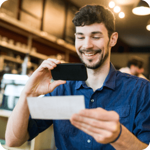 Guy taking a photo of his check using his cell phone for mobile deposit.