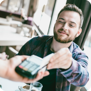 Happy man paying for his lunch with a credit card.