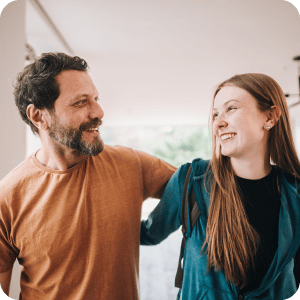 Father and daughter looking at each other and smiling.